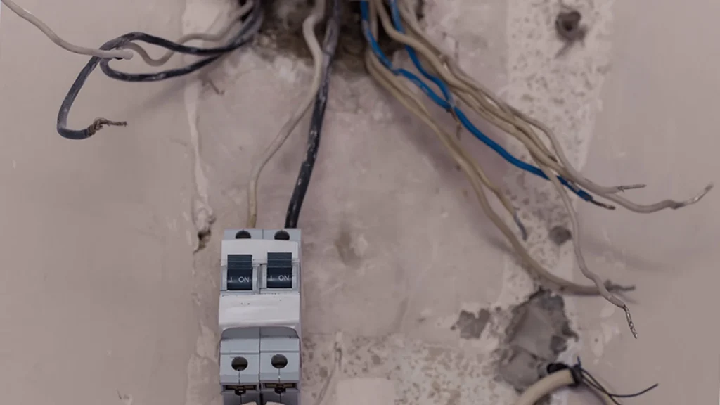 Electrician inspecting older aluminum branch wiring in electrical panel
