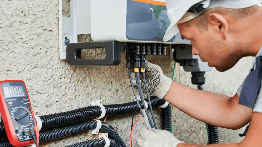 Electrician installing electrical panel in detached garage
