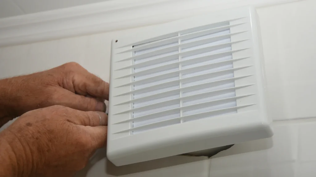 Electrician wiring a bathroom exhaust fan